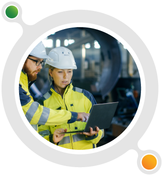 Two engineers are discussing plans on a laptop.