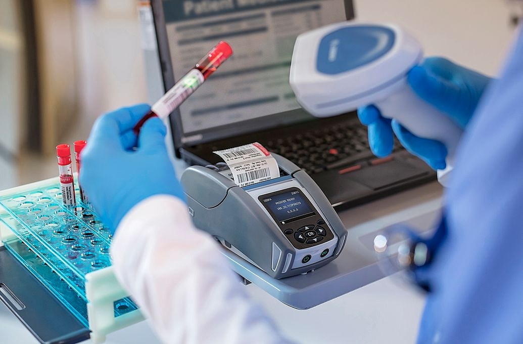 nurse at machine scanning blood sample