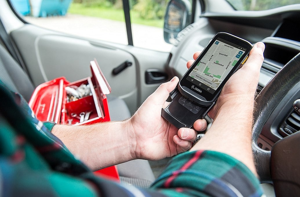 worker checking phone sitting in car