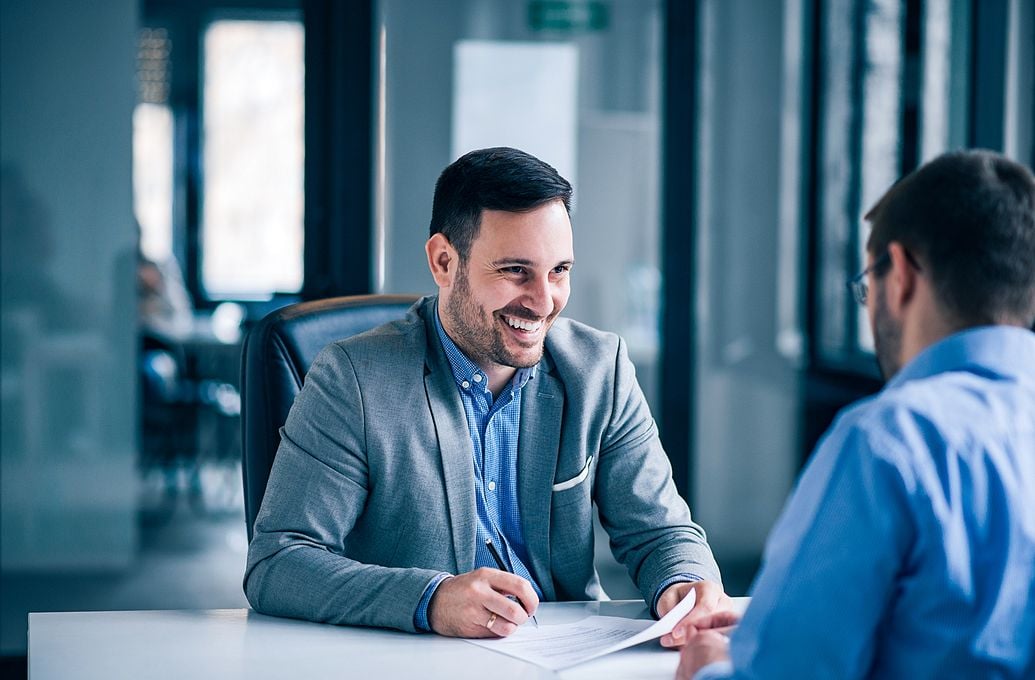 two business men talking at desk