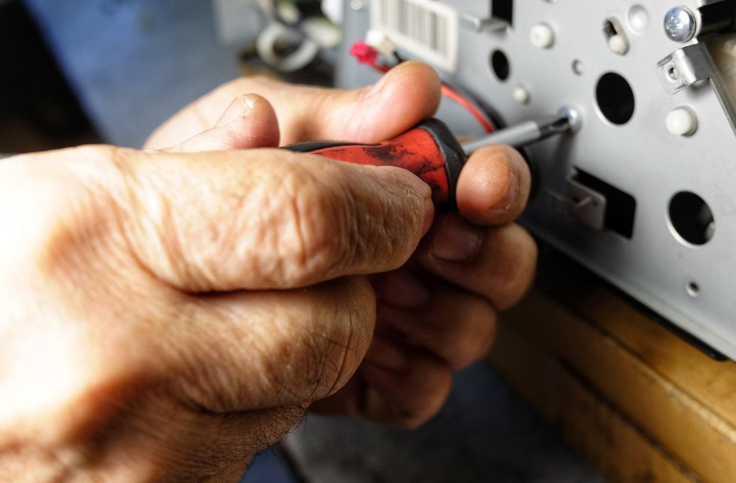 computer being fixed with screwdriver 