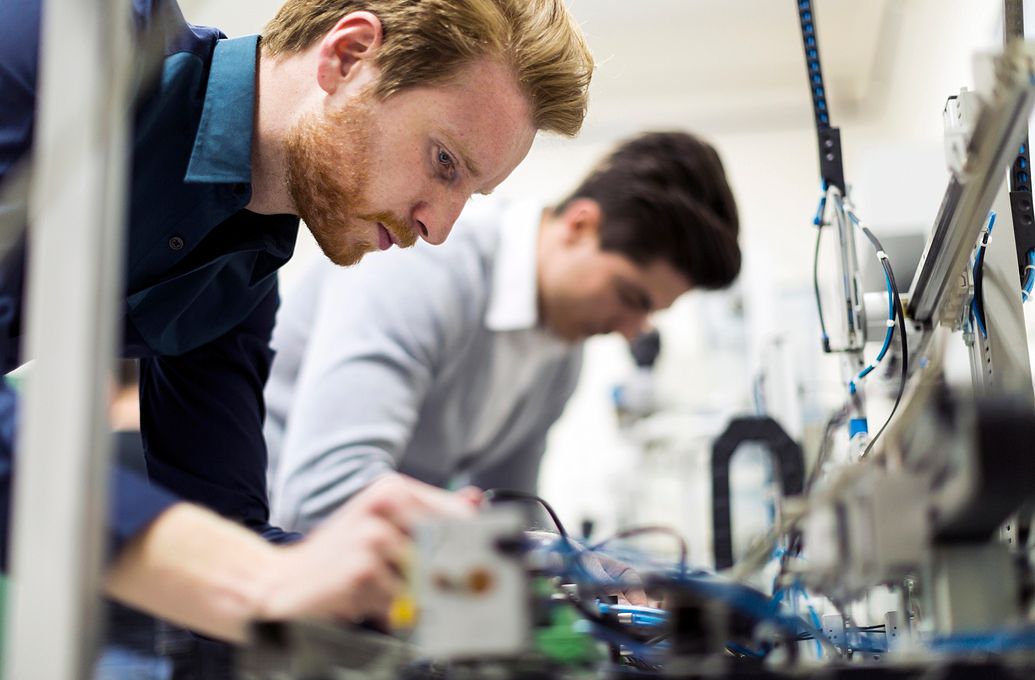 two men making equipment repairs