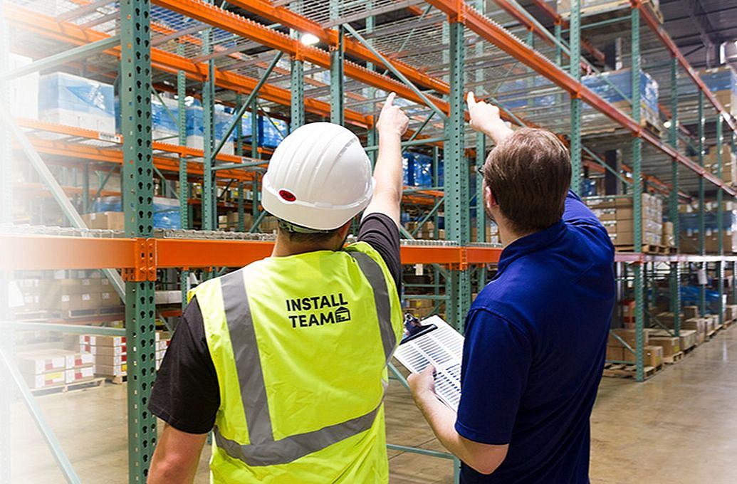 two men in warehouse pointing at shelve