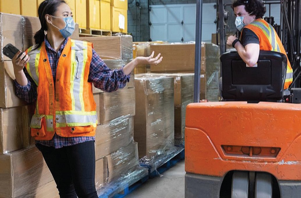 two workers talking in warehouse